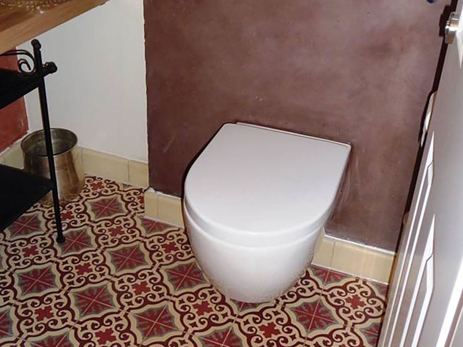 Baño con losa floral hidráulica en tonos rojos
