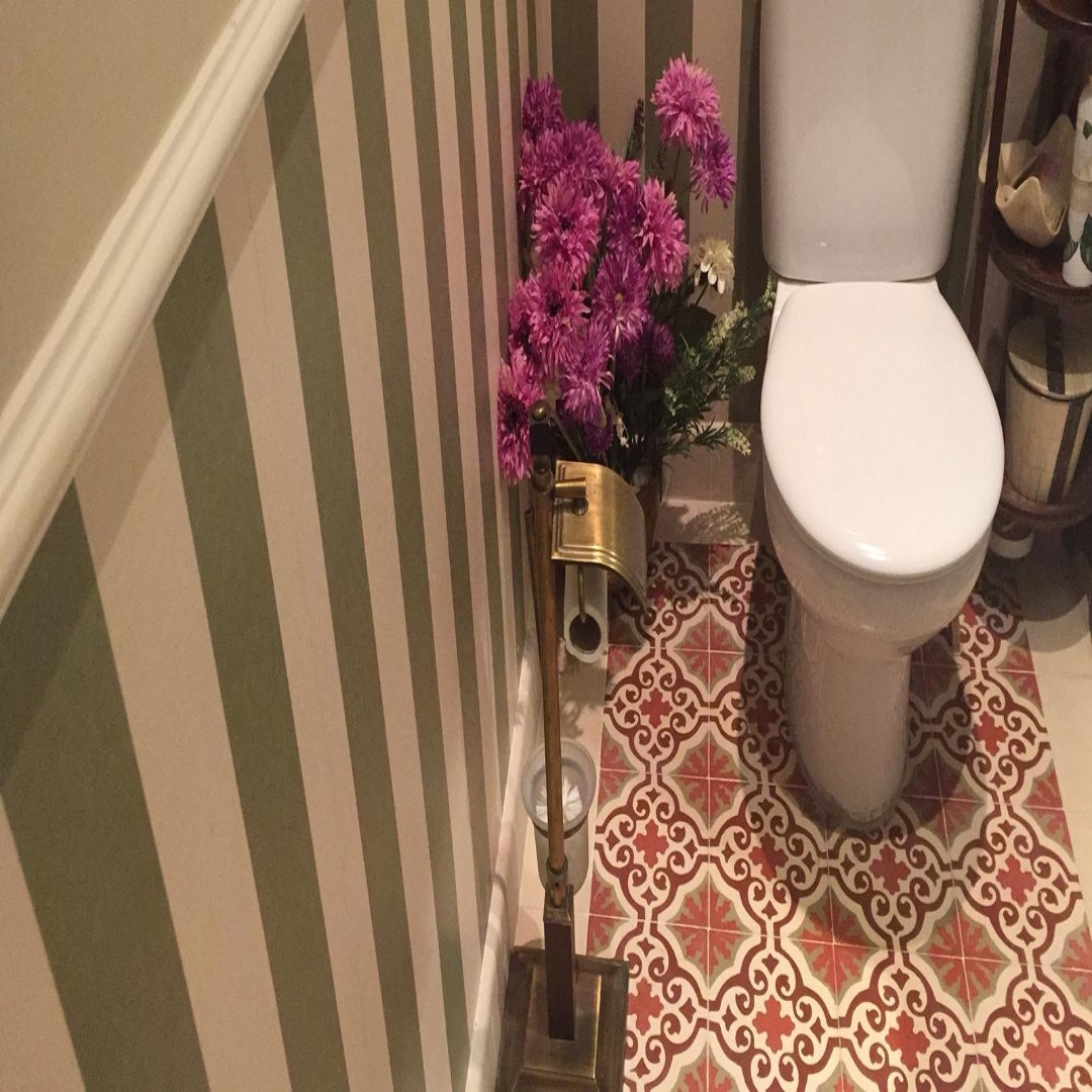 Baño con mosáicos florales hidráulicos en tonos rojos y grises