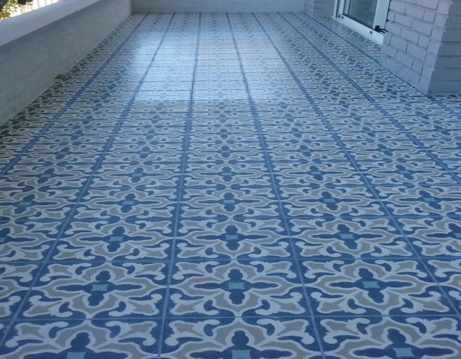 Suelo de terraza con mosáicos hidráulicos florales en distintos tonos de azul y gris